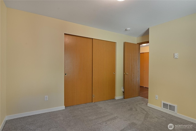 unfurnished bedroom with carpet flooring, a closet, and baseboards
