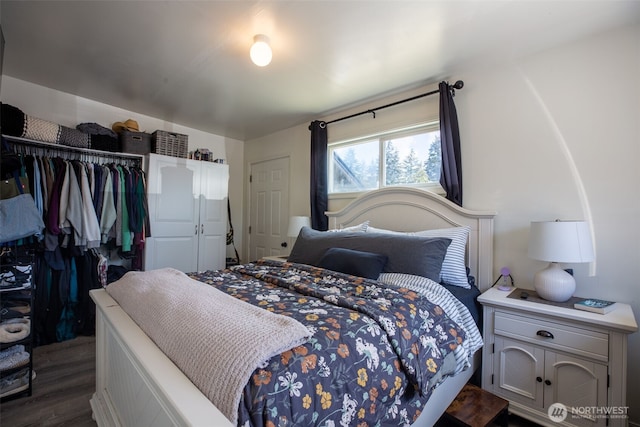 bedroom with dark wood-style floors and a closet