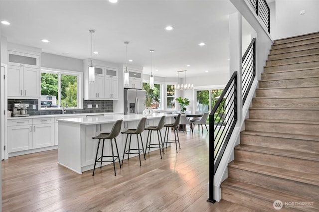 5010 NW Dr, Bellingham, WA 98226 - kitchen with stainless steel fridge with ice dispenser, white cabinets, healthy amount of natural light, a large island, and recessed lighting