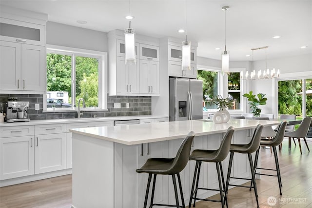 5010 NW Dr, Bellingham, WA 98226 - kitchen featuring appliances with stainless steel finishes, a kitchen island, light countertops, tasteful backsplash, and white cabinetry