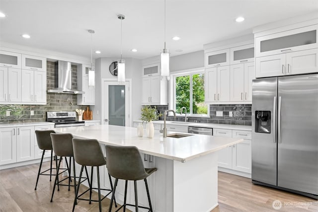 5010 NW Dr, Bellingham, WA 98226 - kitchen featuring appliances with stainless steel finishes, wall chimney exhaust hood, backsplash, a center island with sink, and recessed lighting