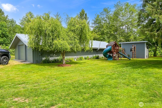 5010 NW Dr, Bellingham, WA 98226 - view of grassy yard featuring a playground, a garage, and an outbuilding