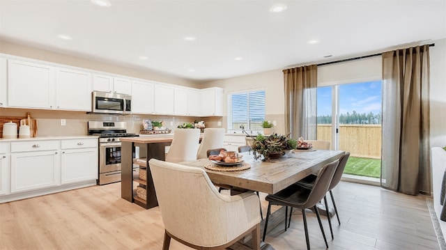 dining room with light wood-style flooring and recessed lighting