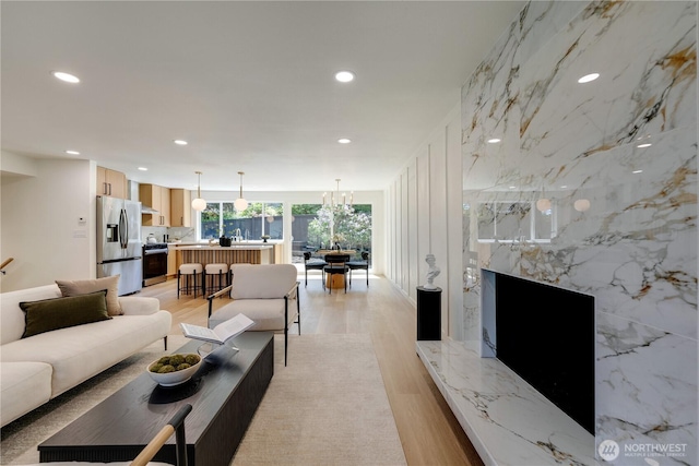 living area with light wood-type flooring and recessed lighting