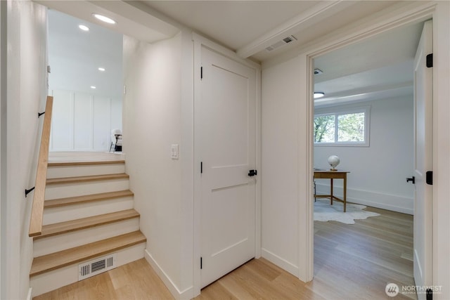 stairway with wood finished floors, baseboards, and recessed lighting