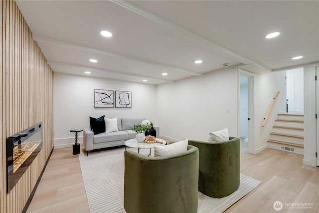 living area featuring light wood finished floors, stairs, baseboards, and recessed lighting