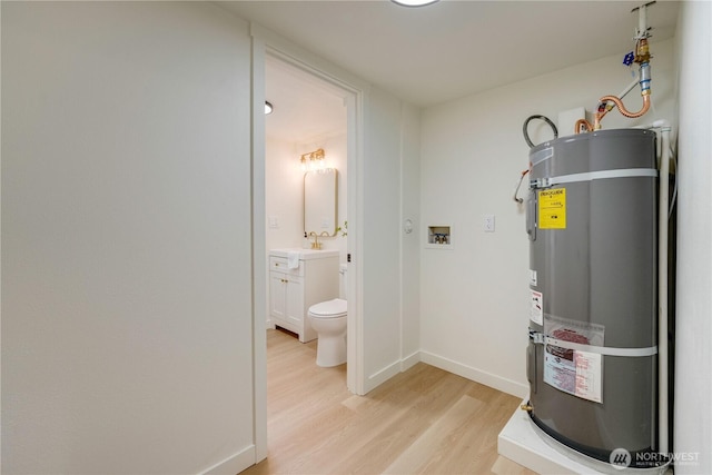 utility room featuring secured water heater and a sink
