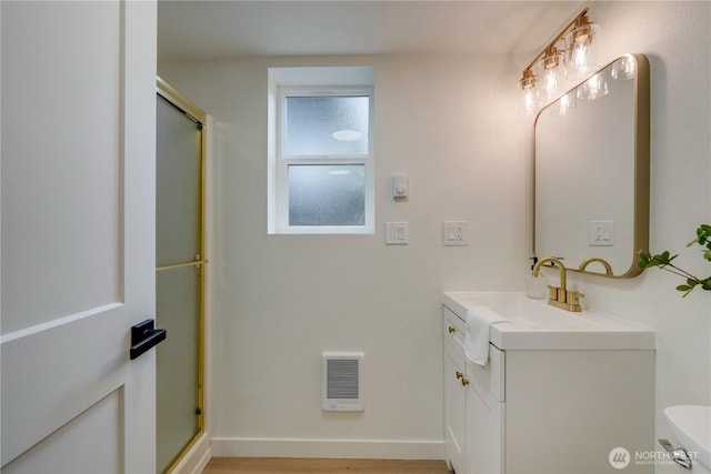 full bath with an enclosed shower, vanity, and toilet