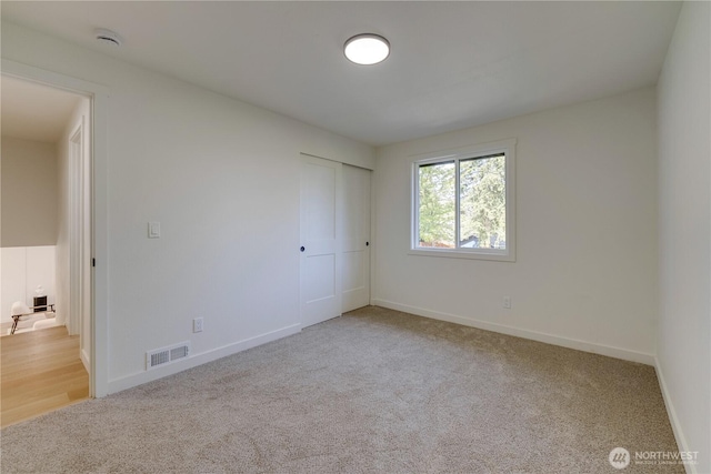 unfurnished bedroom featuring carpet floors, baseboards, and a closet