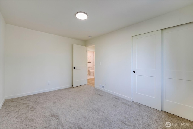 unfurnished bedroom featuring carpet flooring, baseboards, and a closet