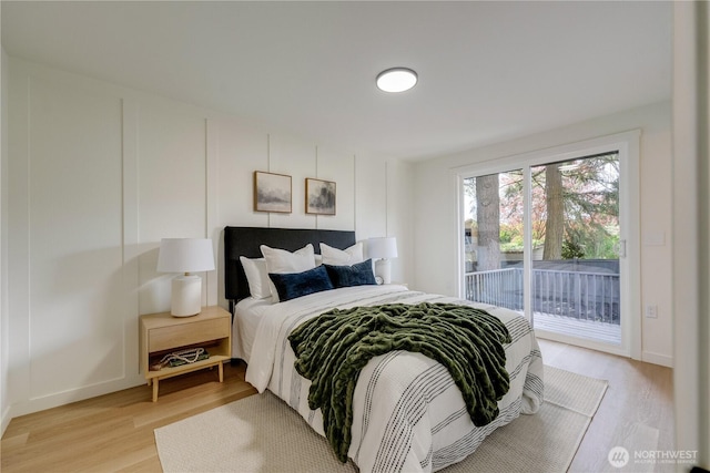 bedroom featuring access to exterior, light wood-type flooring, and baseboards