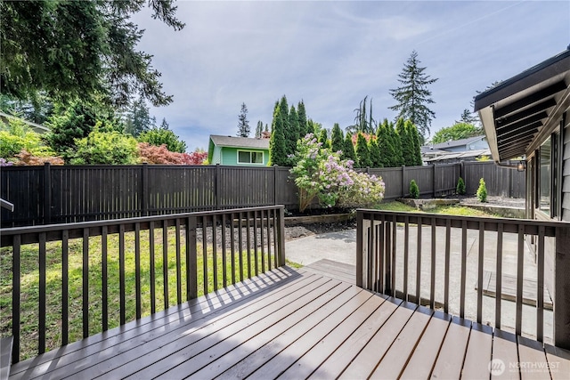 wooden terrace with a fenced backyard