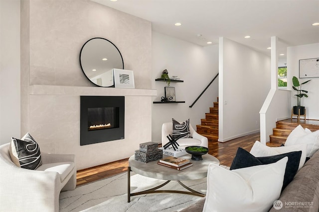living room with stairway, a fireplace, recessed lighting, and wood finished floors