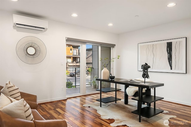 office area with wood finished floors, baseboards, a wall unit AC, and recessed lighting