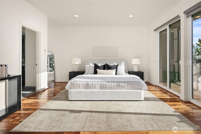 bedroom with recessed lighting, access to outside, dark wood-type flooring, and multiple windows