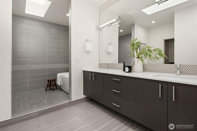 bathroom featuring a sink, double vanity, and a skylight