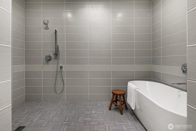 full bath featuring tiled shower and a freestanding tub