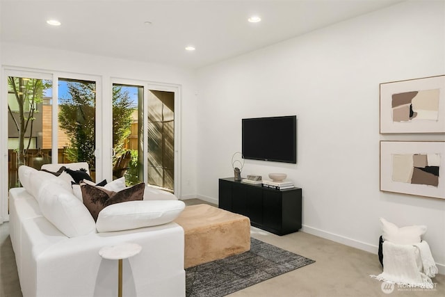 carpeted living area featuring baseboards and recessed lighting