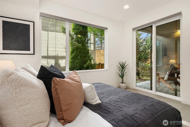 carpeted bedroom featuring recessed lighting, baseboards, access to exterior, and multiple windows