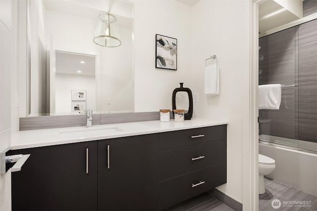 full bathroom featuring toilet, vanity, and enclosed tub / shower combo