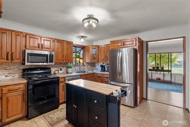 kitchen with stainless steel appliances, a sink, light countertops, and tasteful backsplash