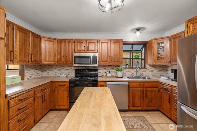 kitchen featuring stainless steel appliances, a sink, butcher block counters, and light tile patterned floors