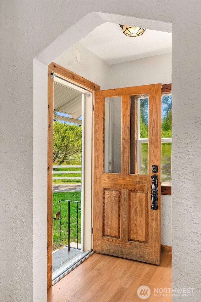 25443 Pioneer Way NW, Poulsbo, WA 98370 - doorway to outside with a textured wall, light wood-type flooring, and plenty of natural light