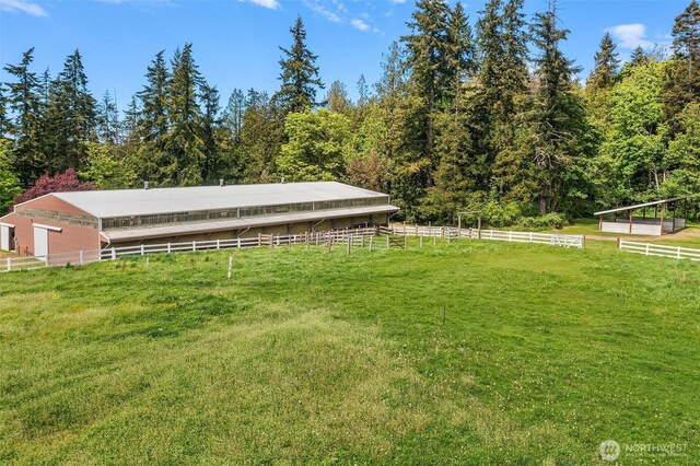 25443 Pioneer Way NW, Poulsbo, WA 98370 - view of yard featuring a forest view, an exterior structure, and an outbuilding