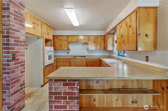 2734 Sunset Dr W, University Place, WA 98466 - kitchen featuring a sink, a peninsula, stainless steel gas stovetop, white oven, and light countertops