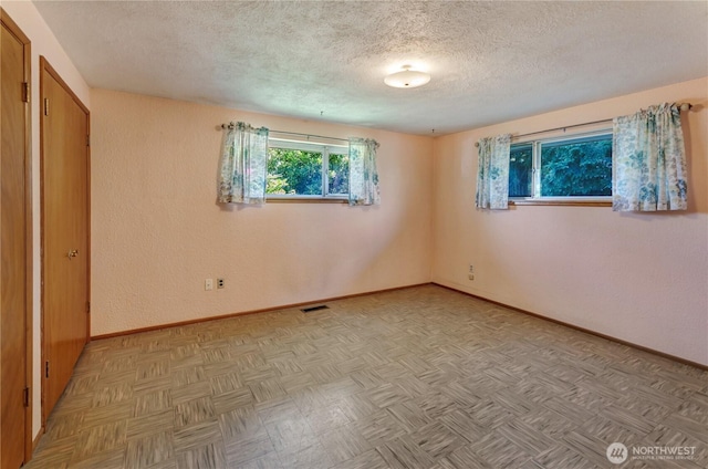 2734 Sunset Dr W, University Place, WA 98466 - unfurnished bedroom featuring baseboards, visible vents, and a textured ceiling