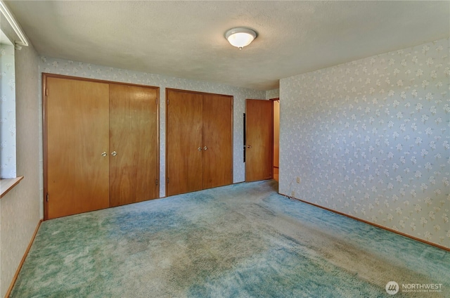 2734 Sunset Dr W, University Place, WA 98466 - unfurnished bedroom featuring two closets, carpet floors, and wallpapered walls