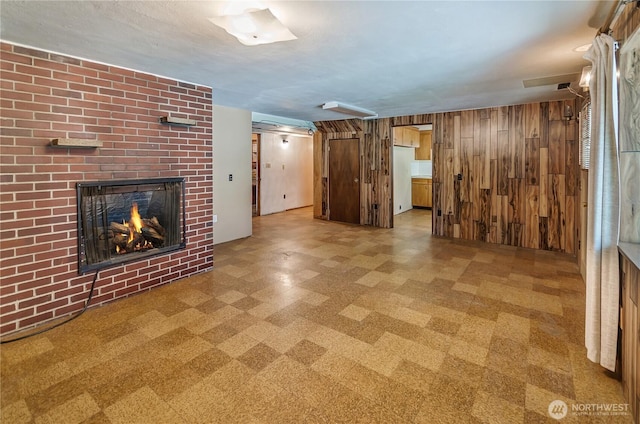 2734 Sunset Dr W, University Place, WA 98466 - unfurnished living room with tile patterned floors, wood walls, and a fireplace