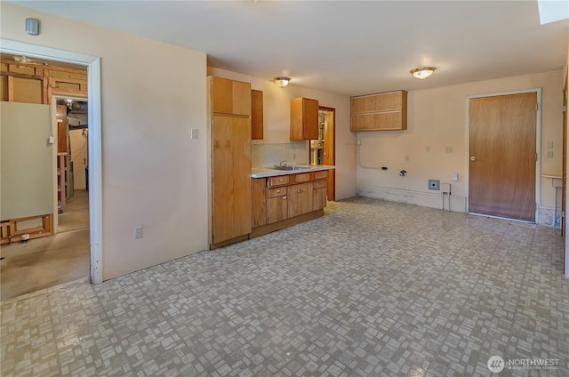 2734 Sunset Dr W, University Place, WA 98466 - kitchen with a sink, brown cabinetry, tasteful backsplash, and light countertops