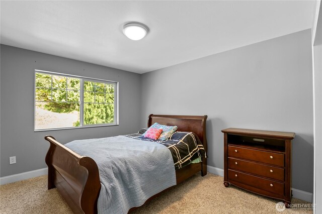 bedroom featuring light colored carpet and baseboards