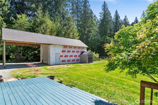 deck with an outbuilding, a lawn, and a shed
