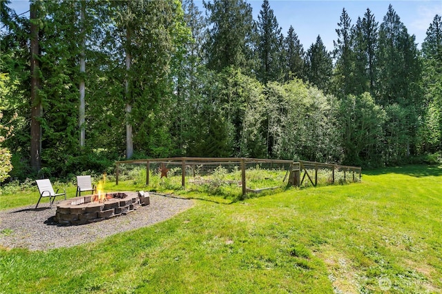 view of green lawn with a fire pit
