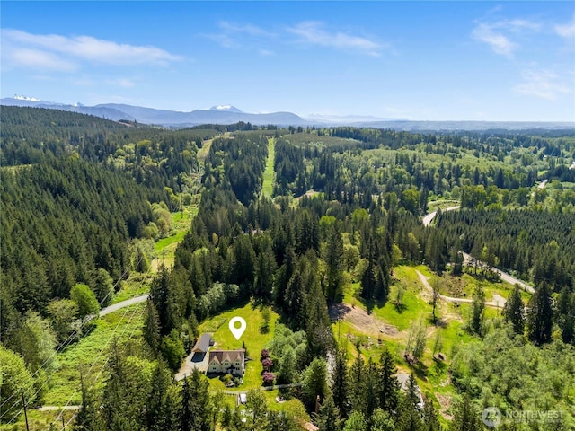 aerial view of a heavily wooded area and a mountainous background