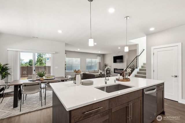 kitchen featuring dark wood-style flooring, light countertops, a sink, and dishwasher