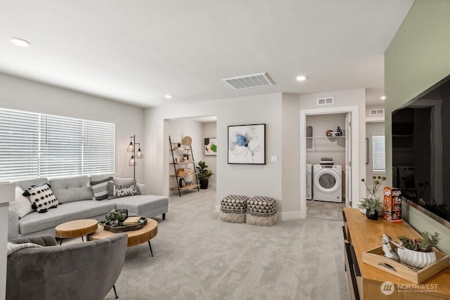 living room with light colored carpet, recessed lighting, independent washer and dryer, and visible vents
