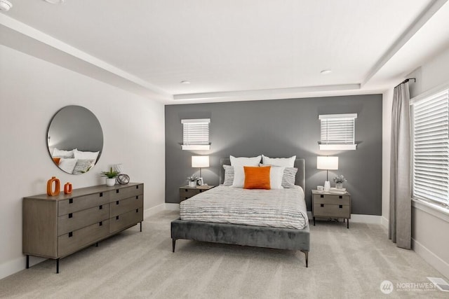 bedroom featuring light colored carpet, multiple windows, and baseboards