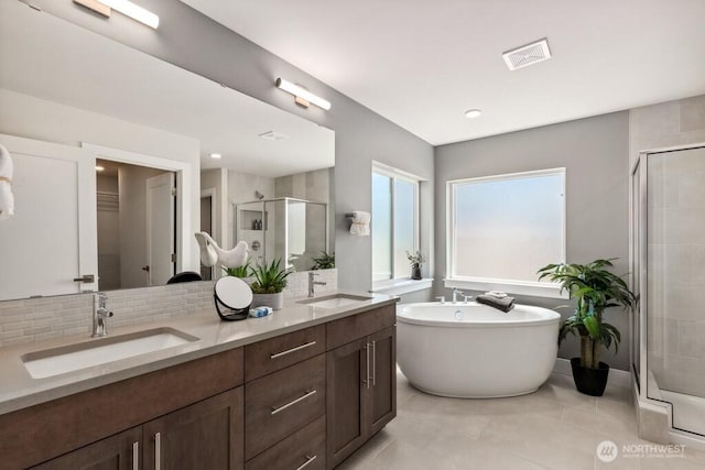 full bath with a stall shower, a freestanding bath, visible vents, and a sink