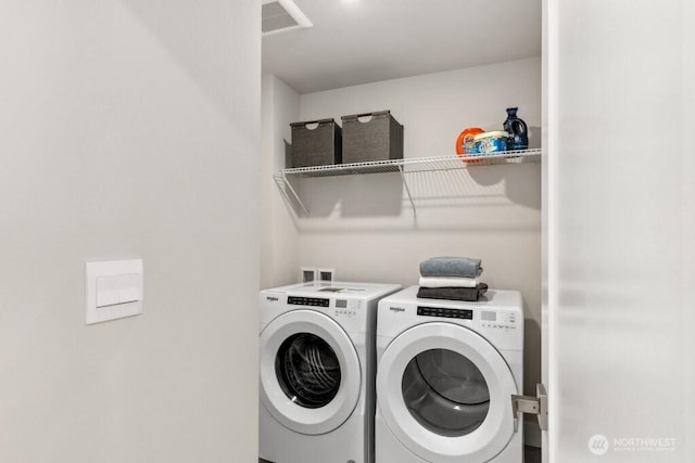 washroom featuring laundry area, separate washer and dryer, and visible vents