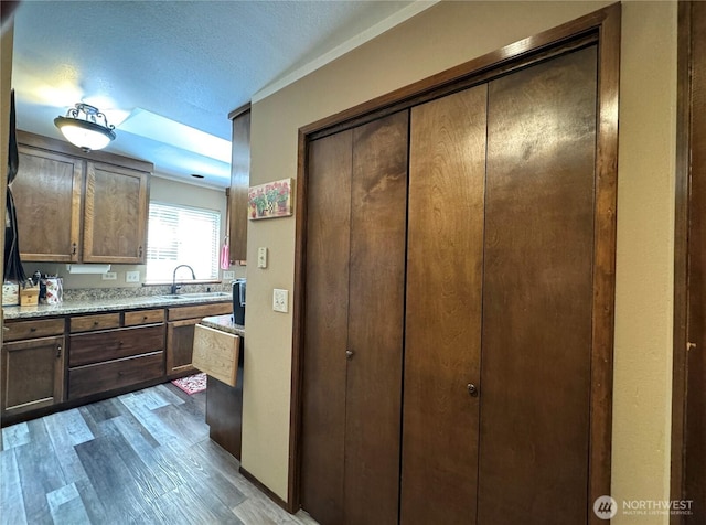 70 Cedar Hill Ln, Sequim, WA 98382 - kitchen featuring a sink, wood finished floors, a textured ceiling, and dark brown cabinetry