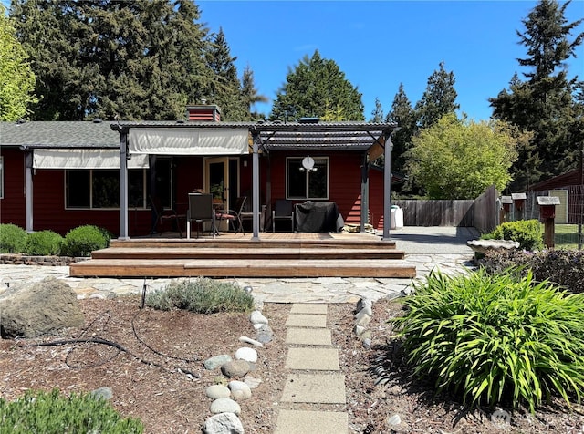 70 Cedar Hill Ln, Sequim, WA 98382 - rear view of property with fence, a wooden deck, and a chimney