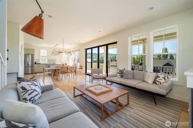 living room with light wood-style floors, a chandelier, and recessed lighting