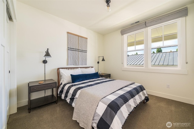 bedroom featuring dark colored carpet and baseboards