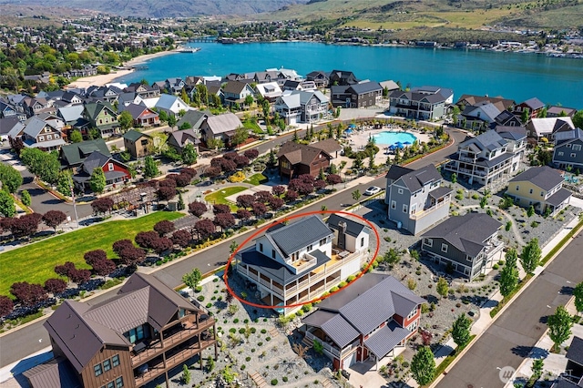 aerial view of residential area featuring a water and mountain view and a pool