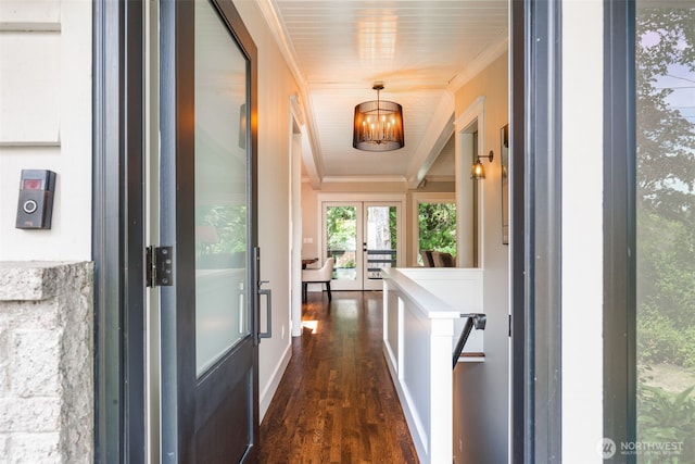 hall featuring a chandelier, dark wood-style flooring, ornamental molding, and baseboards