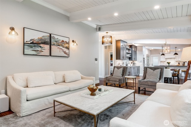 living area featuring beamed ceiling, wood finished floors, recessed lighting, baseboards, and wooden ceiling