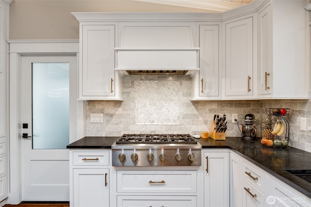 kitchen with stainless steel gas cooktop, white cabinets, backsplash, and custom exhaust hood
